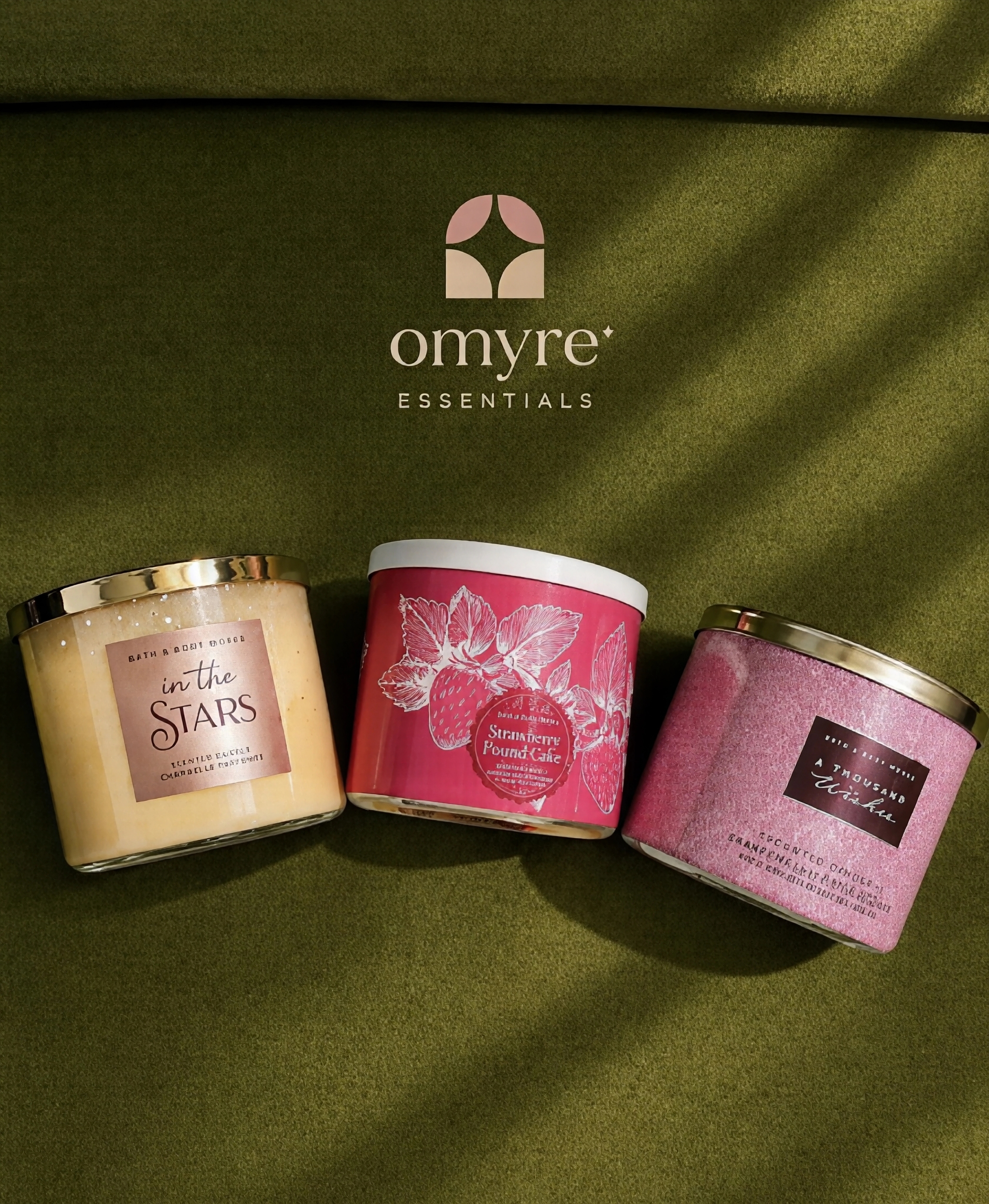 Omyre Essentials three-wick candles on olive velvet
