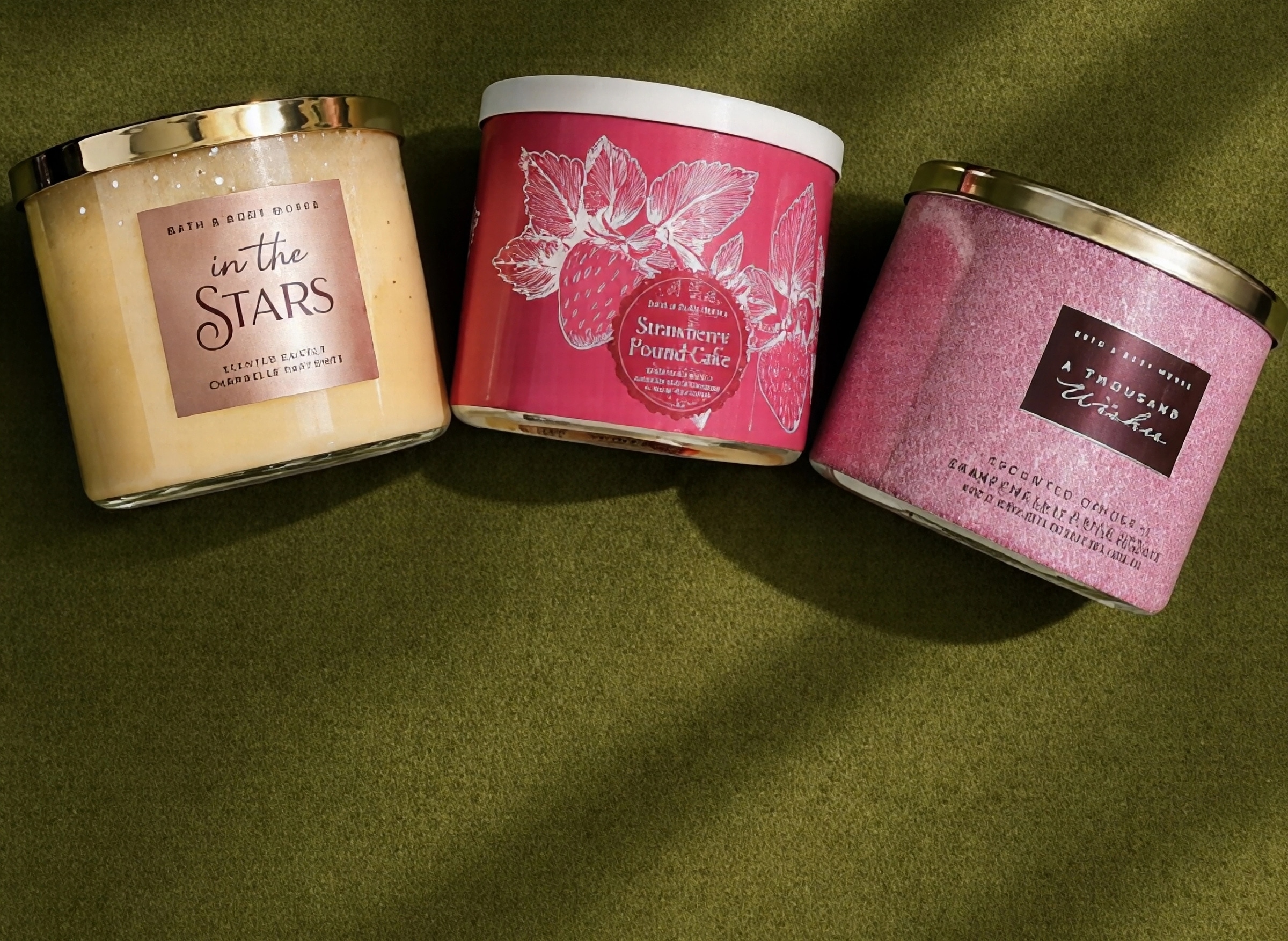 Three-wick candles on olive velvet